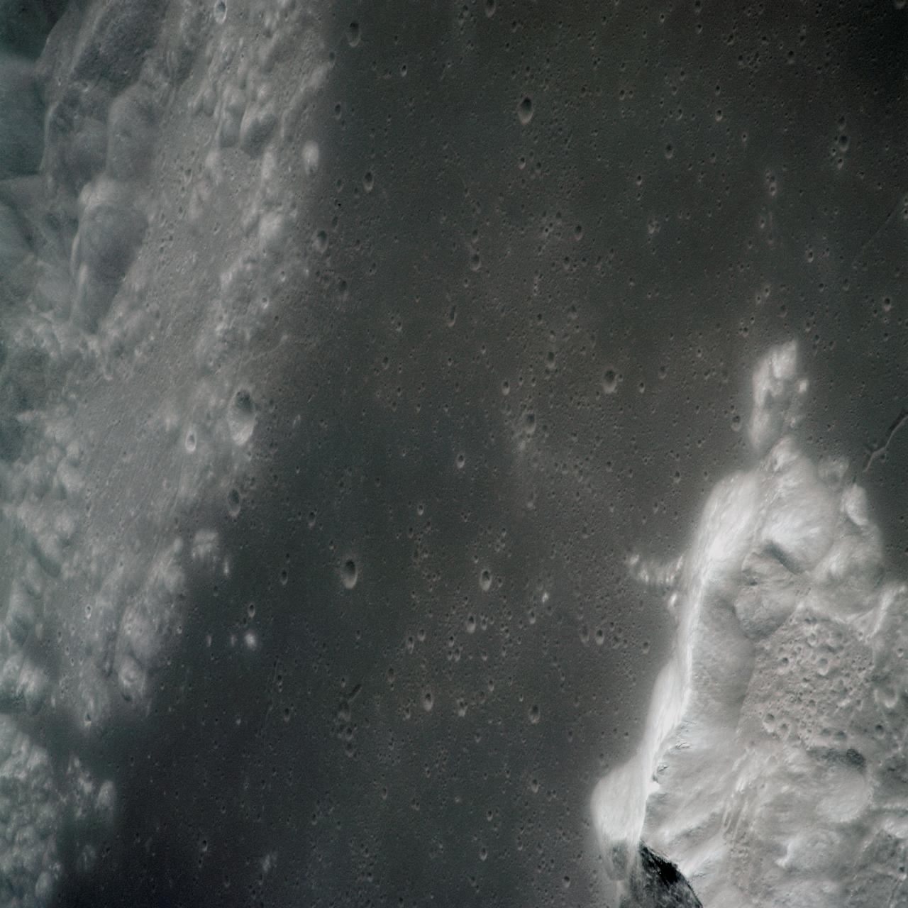 AS15-97-13160 (31 July-2 Aug. 1971) --- A view of a portion of the crater Tsiolkovsky located in the highlands on the farside of the moon, as photographed from the Apollo 15 Command and Service Modules (CSM) by astronaut Alfred M. Worden, command module pilot. Note the dark, flat crater floor surrounding the very prominent central mountains. The mountains are in the northeastern corner of the photograph. The other upland area comprises part of the southwestern edge of the crater. While astronauts David R. Scott, commander, and James B. Irwin, lunar module pilot, descended in the Lunar Module (LM) "Falcon" to explore the moon, astronaut Worden remained with the CSM in lunar orbit.
