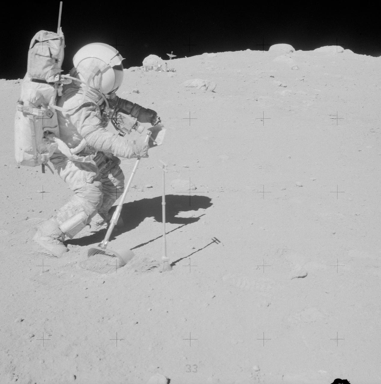 AS16-106-17340 (23 April 1972) --- Astronaut John W. Young, commander of the Apollo 16 lunar landing mission, is photographed collecting lunar samples near North Ray Crater during the third Apollo 16 extravehicular activity (EVA) at the Descartes landing site. This picture was taken by astronaut Charles M. Duke Jr., lunar module pilot. Young is using the lunar surface rake and a set of tongs. The Lunar Roving Vehicle (LRV) is parked in the field of large boulders in the background. While astronauts Young and Duke descended in the Lunar Module (LM) "Orion" to explore the moon, astronaut Thomas K. Mattingly II, command module pilot, remained with the Command and Service Modules (CSM) in lunar orbit.