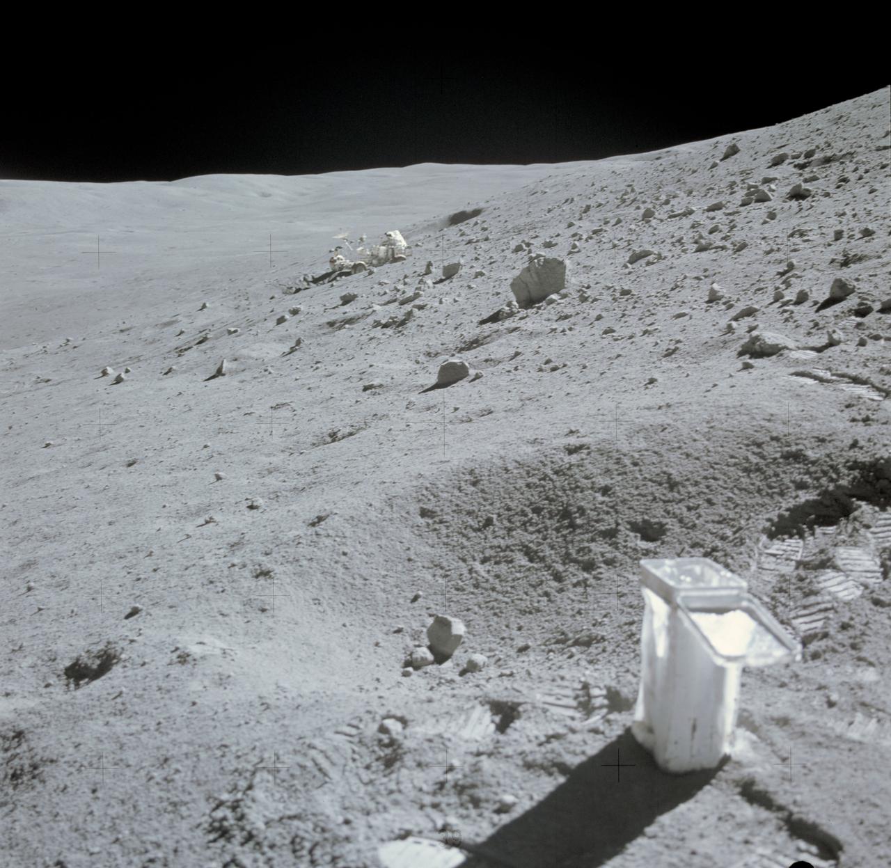 AS16-107-17473 (22 April 1972) --- The Lunar Roving Vehicle (LRV) appears to be parked in a deep lunar depression, on the slope of Stone Mountain. This photograph of the lunar scene at Station No. 4 was taken during the second Apollo 16 extravehicular activity (EVA) at the Descartes landing site. A sample collection bag is in the right foreground. Note field of small boulders at upper right. While astronauts John W. Young, commander, and Charles M. Duke Jr., lunar module pilot, descended in the Lunar Module (LM) "Orion" to explore the moon, astronaut Thomas K. Mattingly II, command module pilot, remained with the Command and Service Modules (CSM) in lunar orbit.