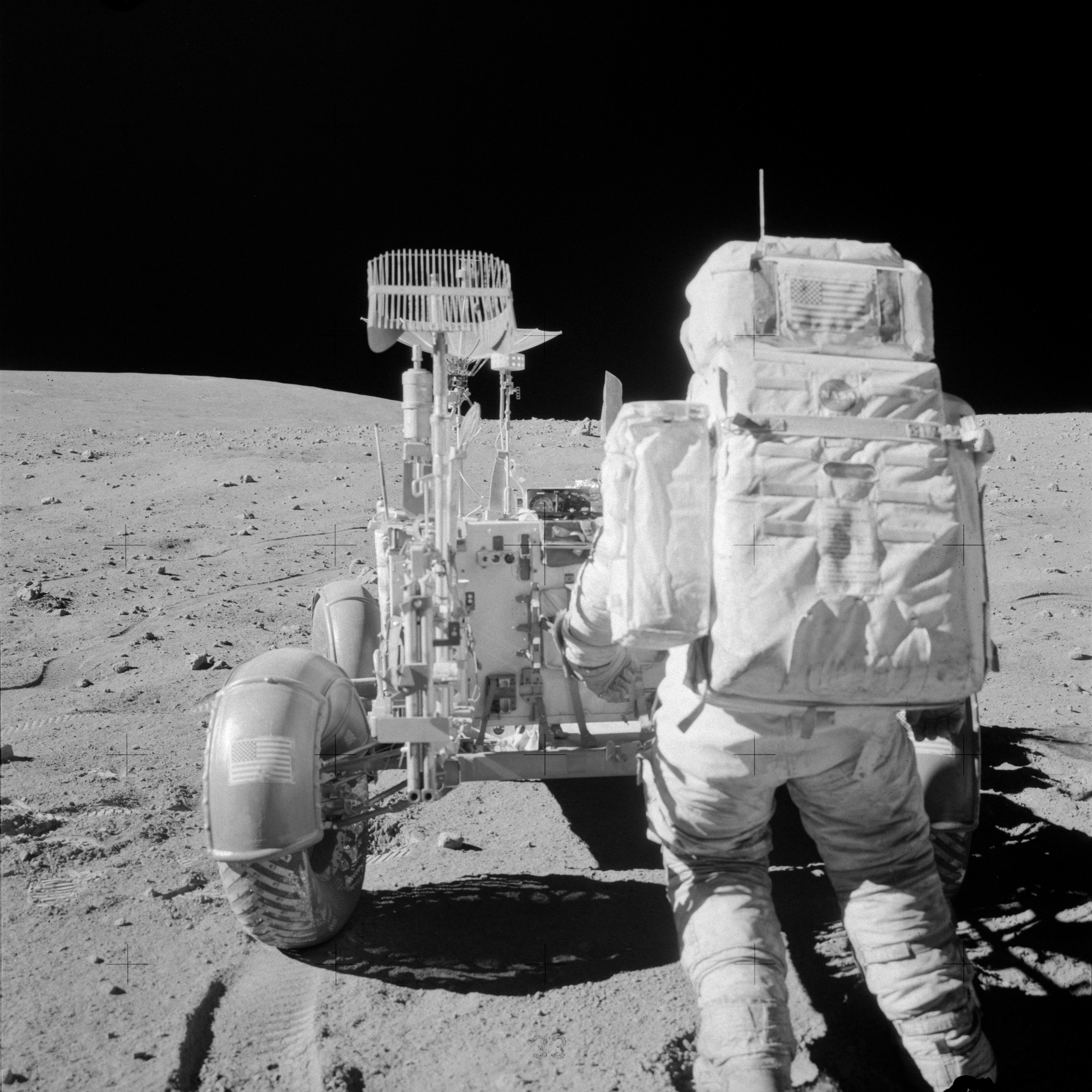 AS16-108-17622 (22 April 1972) --- Astronaut John W. Young, commander of the Apollo 16 lunar landing mission, reaches for tools in the Apollo Lunar Hand Tool Carrier at the aft end of the Lunar Roving Vehicle (LRV) during the second Apollo 16 extravehicular activity (EVA) at the Descartes landing site. This photograph was taken by astronaut Charles M. Duke Jr., lunar module pilot. This view is looking south from the base of Stone Mountain. While astronauts Young and Duke descended in the Lunar Module (LM) "Orion" to explore the Descartes highlands region of the moon, astronaut Thomas K. Mattingly II, command module pilot, remained with the Command and Service Modules (CSM) "Casper" in lunar orbit.
