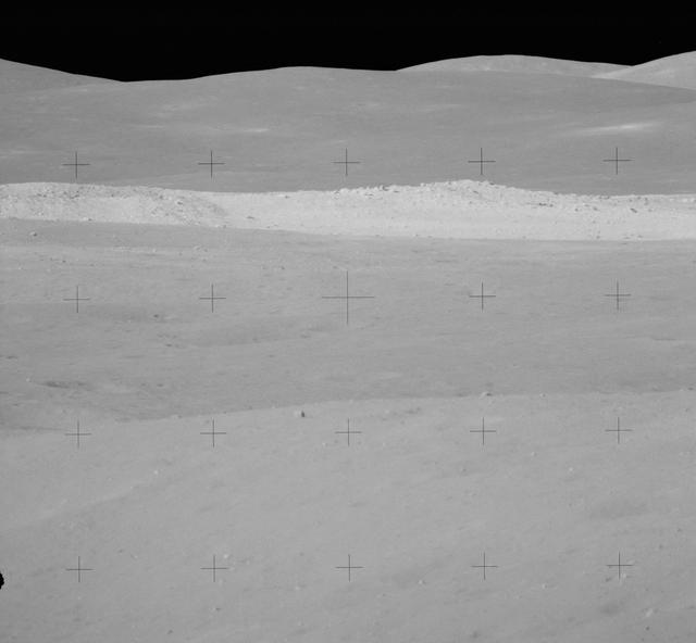NASA image: View of rim of South Ray crater on traverse up Stone Mountain during EVA