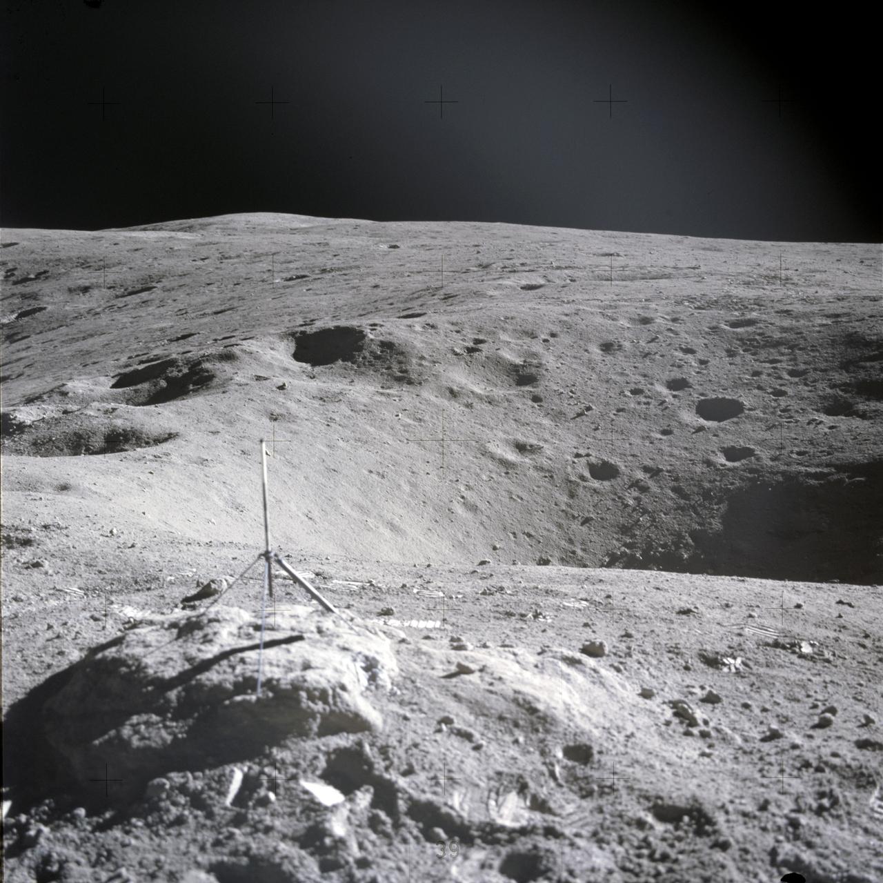 AS16-114-18421 (16-27 April 1972) --- This picture of the lunar surface was photographed by astronaut John W. Young during Apollo 16's first extravehicular activity (EVA) at EVA Station No 1. The instrument near the small crater's edge (foreground) is a gnomon. While astronauts Young, commander; and Charles M. Duke Jr., lunar module pilot; descended in the Apollo 16 Lunar Module (LM) "Orion" to explore the Descartes highlands landing site on the moon, astronaut Thomas K. Mattingly II, command module pilot, remained with the Command and Service Modules (CSM) "Casper" in lunar orbit.