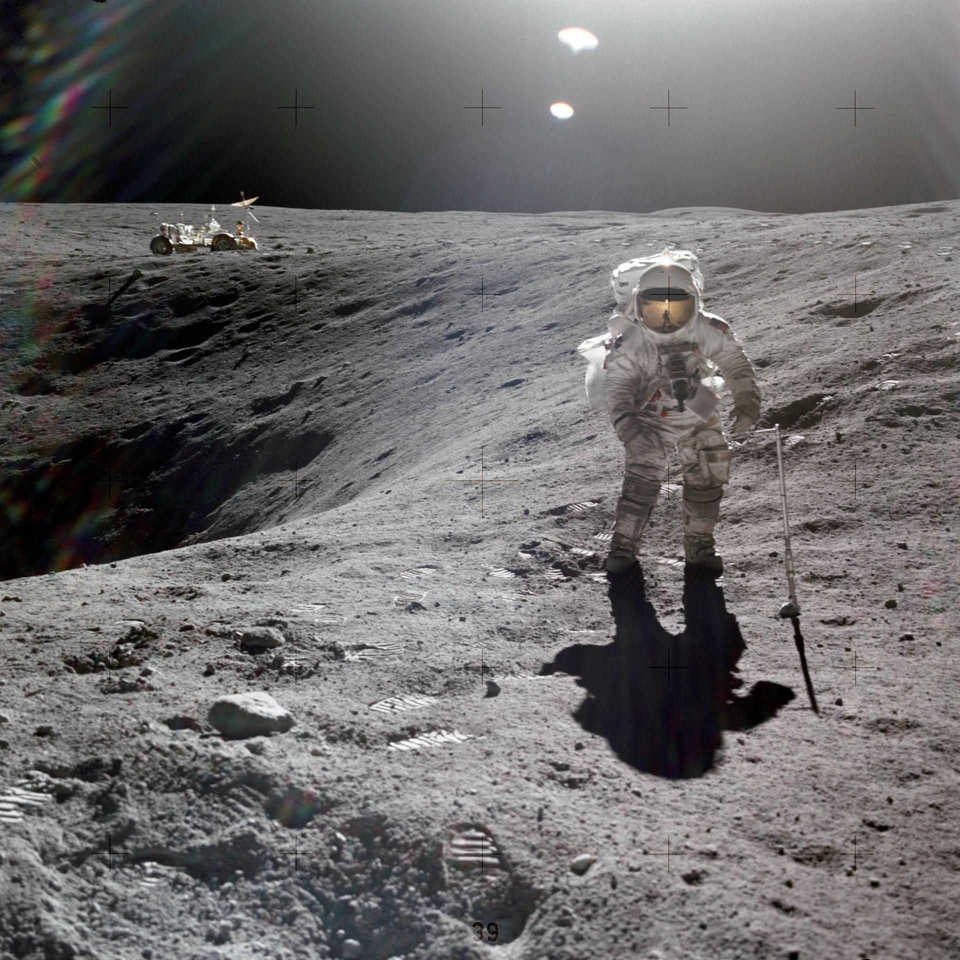 Charlie Duke on a lunar EVA next to a crater