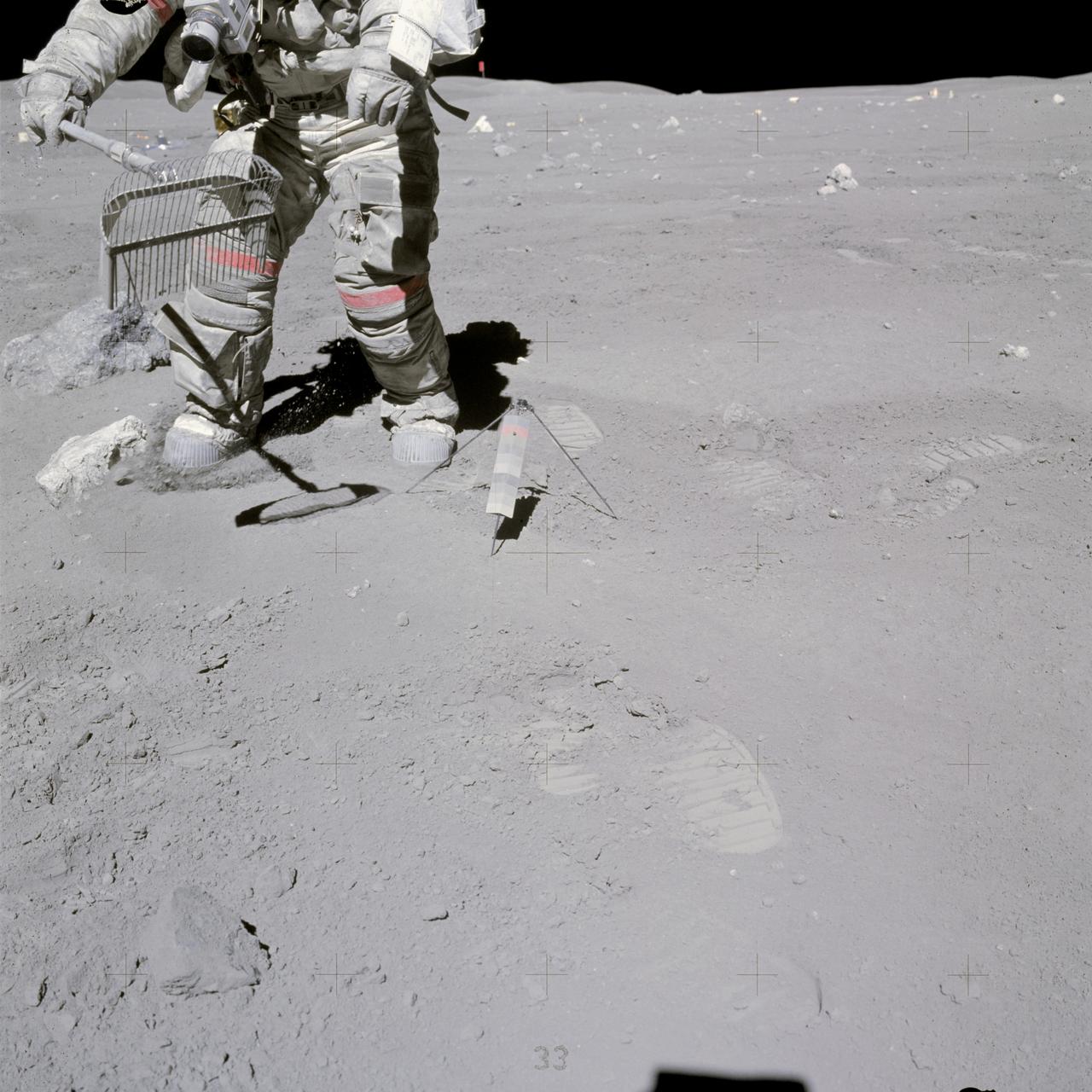 AS16-117-18826 (23 April 1972) --- Astronaut John W. Young collects samples at the North Ray Crater geological site during the mission's third and final Apollo 16 extravehicular activity (EVA). He has a rake in his hand, and the gnomon is near his foot. Note how soiled Young's Extravehicular Mobility Unit (EMU) is. While astronauts Young, commander; and Charles M. Duke Jr., lunar module pilot; descended in the Apollo 16 Lunar Module (LM) "Orion" to explore the Descartes highlands landing site on the moon, astronaut Thomas K. Mattingly II, command module pilot, remained with the Command and Service Modules (CSM) "Casper" in lunar orbit.