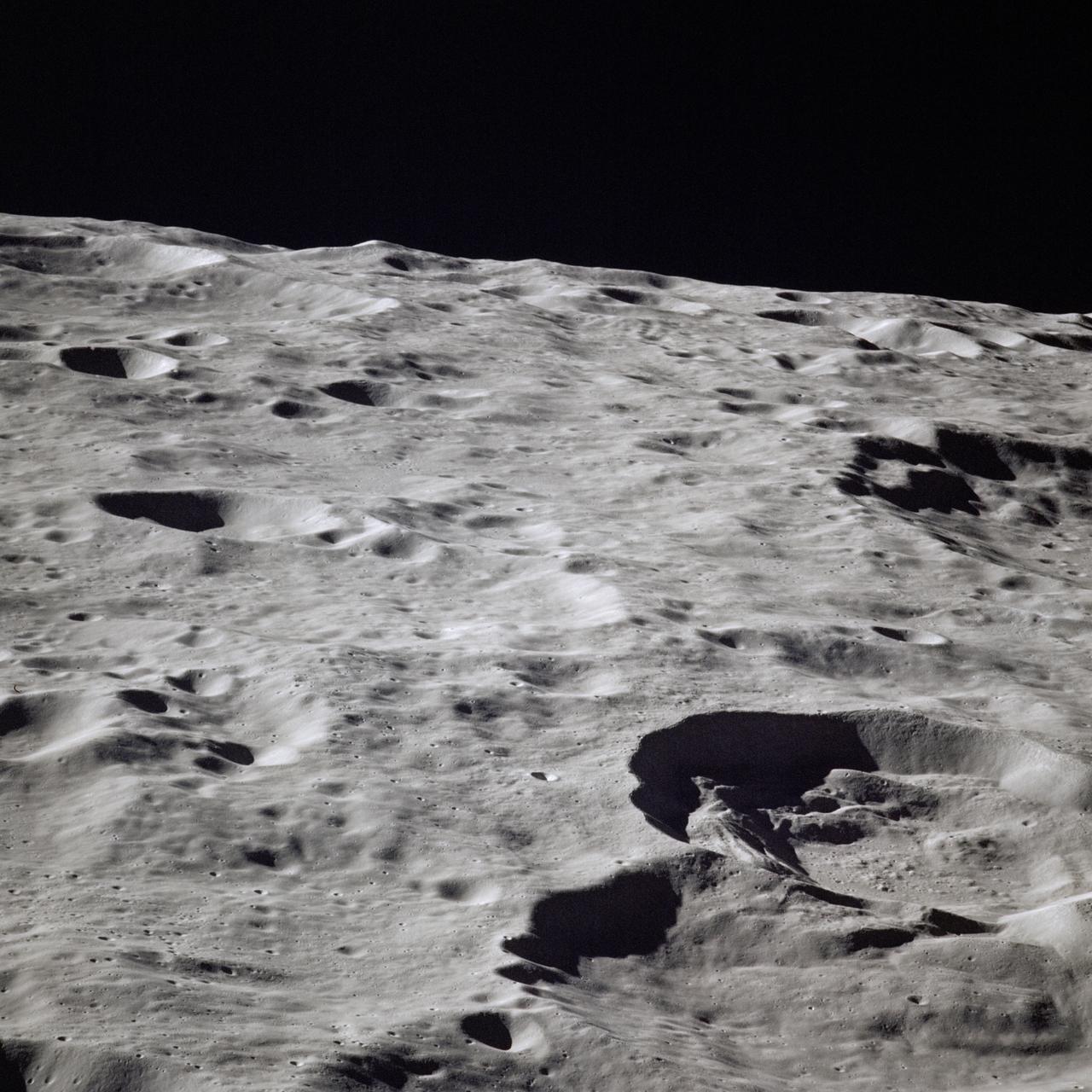 AS16-118-18947 (16-27 April 1972) --- A 250mm view looking north by westward across lunar farside highland terrain, as photographed from the Apollo 16 spacecraft in lunar orbit. The frame is centered at approximately 158 degrees east longitude and 17 degrees north latitude. Van Gent Crater is the lower of two large craters at extreme lower right corner. The top of the two craters is unnamed. The west part of Konstantinov Crater is at extreme right center. Nagaoka Crater is just below the horizon at upper left.