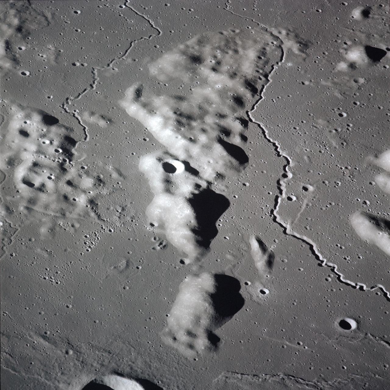 AS16-119-19161 (16-27 April 1972) --- The prominent rille feature running through the area is Herigonius I. The coordinates for the center of the area pictured are 14.7 degrees south latitude and 36.4 degrees west longitude. The photo was taken by the Apollo 16 astronauts from the Command and Service Modules (CSM) in lunar orbit. While astronauts John W. Young and Charles M. Duke Jr. descended in the Lunar Module (LM) "Orion" to explore the Descartes highlands region of the moon, astronaut Thomas K. (Ken) Mattingly II, remained with the CSM "Casper" in lunar orbit.