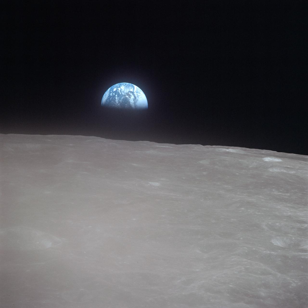 AS16-120-19187 (19 April 1972) --- Apollo 16 astronauts captured this Earth rise scene with a handheld Hasselblad camera during the second revolution of the moon. Identifiable craters seen on the moon include Saha, Wyld, and Saenger. Much of the terrain seen here is never visible from Earth, as the Command Module (CM) was just passing onto what is known as the dark side or far side of the moon. Crewmen aboard the CM at the time the photo was made were astronauts John W. Young, Thomas K. Mattingly II and Charles M. Duke Jr. Mattingly remained later with the CM in lunar orbit while Young and Duke descended in the lunar module (LM) to explore the surface of the moon.