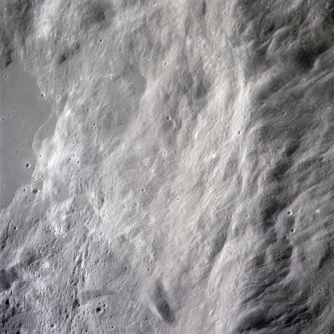 AS16-120-19228 (16-27 April 1972) --- Strongly textured terrain north of the lunar farside King Crater which is centered near 120.5 degrees east longitude and 5.5 degrees north latitude. This near vertical oblique view eastward was photographed from the Apollo 16 spacecraft in lunar orbit with a Hasselblad camera equipped with a 250mm telephoto lens. Several irregular areas characterized by conspicuously smooth surfaces interrupt the rough texture in this view of the eastern quarter of the large, unnamed crater between King and Guyot. Similar "ponds" occur at varied levels in the rim deposits of the nearside craters Copernicus and Tycho. Hold picture with the smooth area at the top.