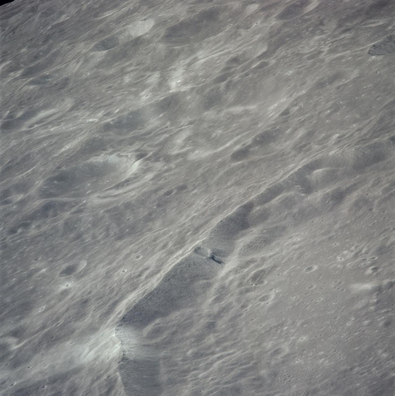 AS16-121-19407 (April 1972) --- An oblique view of a rim of Guyot Crater on the lunar farside, as photographed from the Apollo 16 spacecraft in lunar orbit. The coordinates of the center of Guyot Crater are 116.5 degrees east longitude and 10.5 degrees north latitude. Note the black coloration which appears to be lava flow down the side of the crater rim. While astronauts John W. Young, commander; and Charles M. Duke Jr., lunar module pilot; descended in the Apollo 16 Lunar Module (LM) "Orion" to explore the Descartes highlands site on the moon, astronaut Thomas K. Mattingly II, command module pilot, remained with the Command and Service Modules (CSM) "Casper" in lunar orbit.