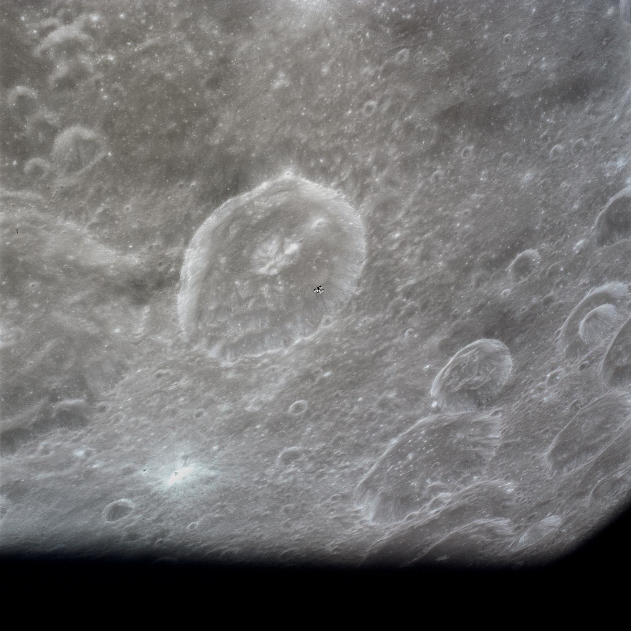 AS16-122-19527 (23 April 1972) --- The Apollo 16 Lunar Module (LM) ascent stage, with astronauts John W. Young and Charles M. Duke Jr. aboard, returns from the lunar surface to rejoin the Command and Service Modules (CSM) in lunar orbit. Astronaut Thomas K. (Ken) Mattingly II took this photograph from the Command Module (CM). The LM is above the Crater Schubert B. The lunar surface area visible in this picture is located at the western edge of Smyth's Sea.