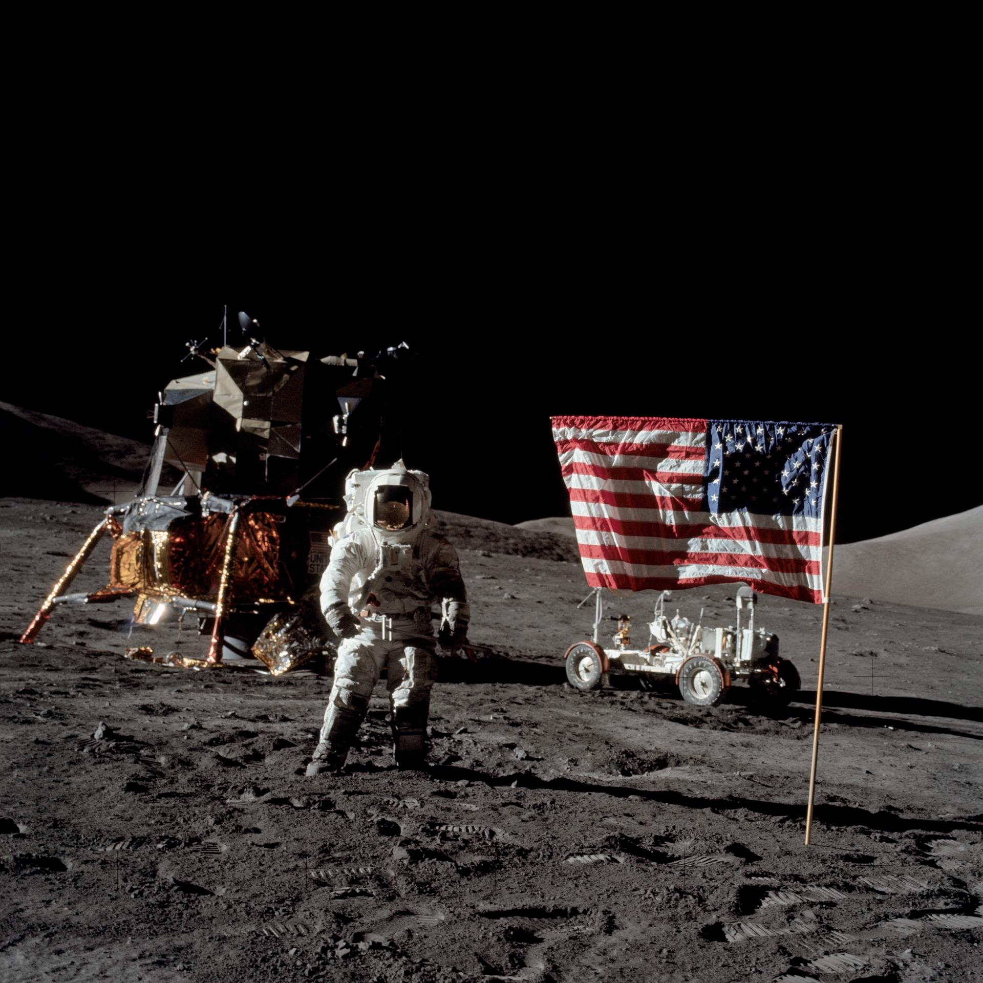 Harrison Schmitt poses next to the American flag and Lunar Module on the Moon