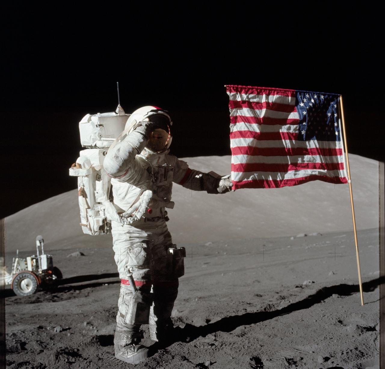AS17-134-20386 (7-19 Dec. 1972) --- Astronaut Eugene A. Cernan, Apollo 17 commander, is photographed next to the deployed United States flag during lunar surface extravehicular activity (EVA) at the Taurus-Littrow landing site. The highest part of the flag appears to point toward our planet Earth in the distant background. This picture was taken by scientist-astronaut Harrison H. Schmitt, lunar module pilot. While astronauts Cernan and Schmitt descended in the Lunar Module (LM) to explore the moon, astronaut Ronald E. Evans, command module pilot, remained with the Command and Service Modules (CSM) in lunar orbit.