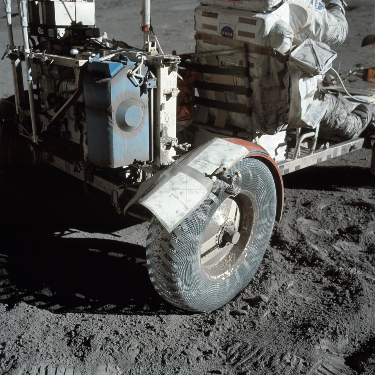 AS17-137-20979 (12 Dec. 1972) --- A close-up view of the lunar roving vehicle (LRV) at the Taurus-Littrow landing site photographed during Apollo 17 lunar surface extravehicular activity. Note the makeshift repair arrangement on the right rear fender of the LRV. During EVA-1 a hammer got underneath the fender and a part of it was knocked off. Astronauts Eugene A. Cernan and Harrison H. Schmitt were reporting a problem with lunar dust because of the damage fender. Following a suggestion from astronaut John W. Young in the Mission Control Center at Houston the crewmen repaired the fender early in EVA-2 using lunar maps and clamps from the optical alignment telescope lamp. Schmitt is seated in the rover. Cernan took this picture.