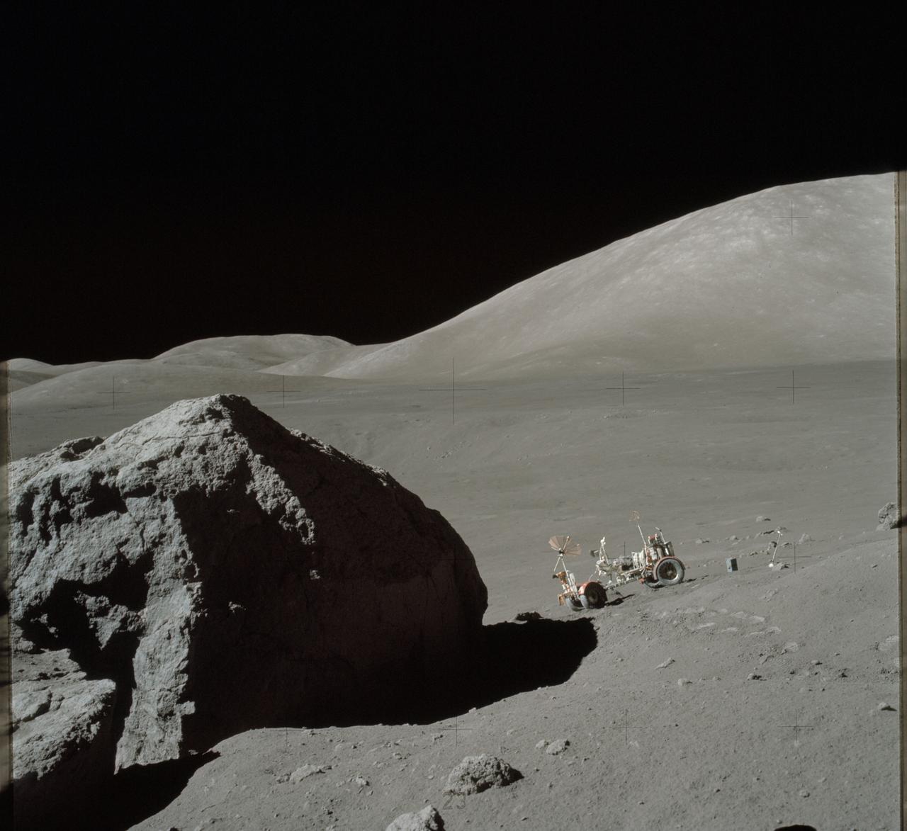 AS17-140-21494 (13 Dec. 1972) --- This view shows the Lunar Roving Vehicle (LRV) parked by an outcrop of rocks by astronauts Eugene A. Cernan and Harrison H. (Jack) Schmitt during their visit to extravehicular activity Station 6 (Henry Crater).