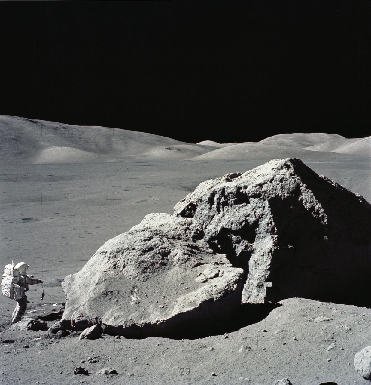 AS17-140-21496 (13 Dec. 1972) --- Scientist-astronaut Harrison H. Schmitt is photographed standing next to a huge, split boulder during the third Apollo 17 extravehicular activity (EVA) at the Taurus-Littrow landing site on the moon. Schmitt is the Apollo 17 lunar module pilot. This picture was taken by astronaut Eugene A. Cernan, commander. While Cernan and Schmitt descended in the Lunar Module (LM) "Challenger" to explore the moon, astronaut Ronald E. Evans, command module pilot, remained with the Apollo 17 Command and Service Modules (CSM) in lunar orbit.