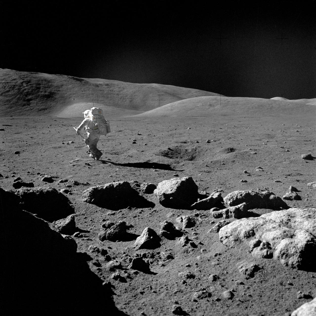 AS17-145-22165 (12 Dec. 1972) --- Scientist-astronaut Harrison H. Schmitt, lunar module pilot, with his adjustable sampling scoop, heads for a selected rock on the lunar surface to retrieve the sample for study. The action was photographed by Apollo 17 crew commander, astronaut Eugene A. Cernan on the mission's second extravehicular activity (EVA), at Station 5 at the Taurus-Littrow landing site. Cernan used a 70mm Hasselblad camera equipped with a 60mm lens and type SO-368 color film for this photograph. While astronauts Cernan and Schmitt descended in the Lunar Module (LM) "Challenger" to explore the Taurus-Littrow region of the moon, astronaut Ronald E. Evans, command module pilot, remained with the Command and Service Modules (CSM) "America" in lunar orbit.