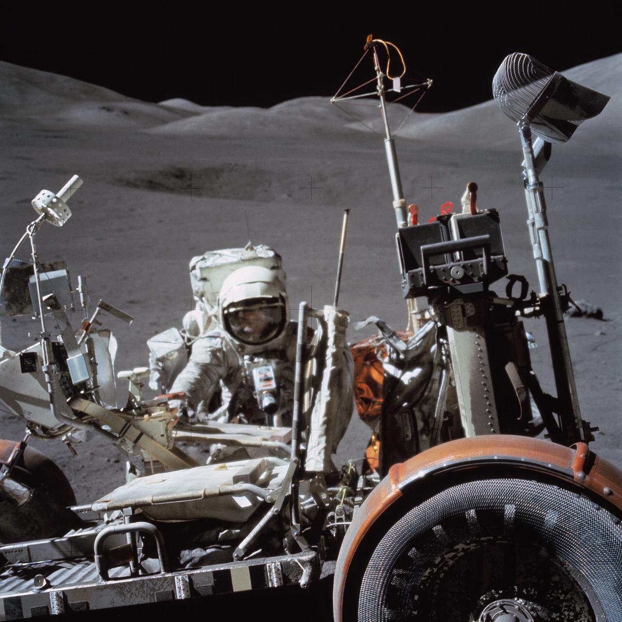 AS17-146-22296 (13 Dec. 1972) --- Astronaut Harrison H. Schmitt, lunar module pilot, works near the Lunar Roving Vehicle (LRV) during the third Apollo 17 extravehicular activity (EVA) at the Taurus-Littrow site on the lunar surface. The front part of the LRV is out of frame at left, but the seats and several geological tools can be seen. The photo was taken by astronaut Eugene A. Cernan, mission commander.
