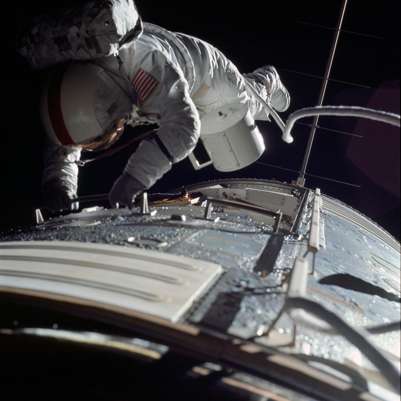 AS17-152-23391 (17 Dec. 1972) --- Astronaut Ronald E. Evans is photographed performing extravehicular activity during the Apollo 17 spacecraft's trans-Earth coast. During his EVA, Evans, command module pilot, retrieved film cassettes from the lunar sounder, mapping camera and panoramic camera. The cylindrical object at Evans' left side is the mapping camera cassette. The total time for the trans-Earth EVA was one hour, seven minutes, 18 seconds, starting at ground elapsed time of 257:25 (2:28 p.m.) and ending at G.E.T. of 258:42 (3:35 p.m.) on Sunday, Dec. 17, 1972.