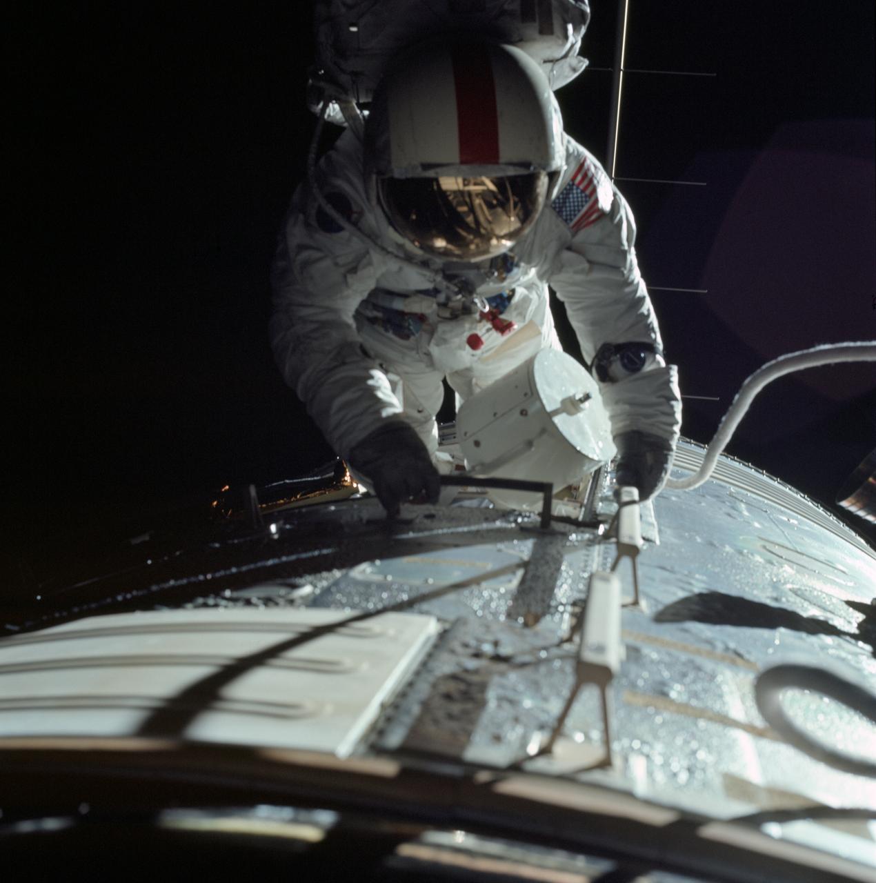 AS17-152-23393 (17 Dec. 1972) --- Astronaut Ronald E. Evans is photographed performing extravehicular activity during the Apollo 17 spacecraft's trans-Earth coast. During his EVA, command module pilot Evans retrieved film cassettes from the Lunar Sounder, Mapping Camera, and Panoramic Camera. The cylindrical object at Evans' left side is the Mapping Camera cassette. The total time for the trans-Earth EVA was one hour seven minutes 18 seconds, starting at ground elapsed time of 257:25 (2:28 p.m.) and ending at ground elapsed timed of 258:42 (3:35 p.m.) on Sunday, Dec. 17, 1972.