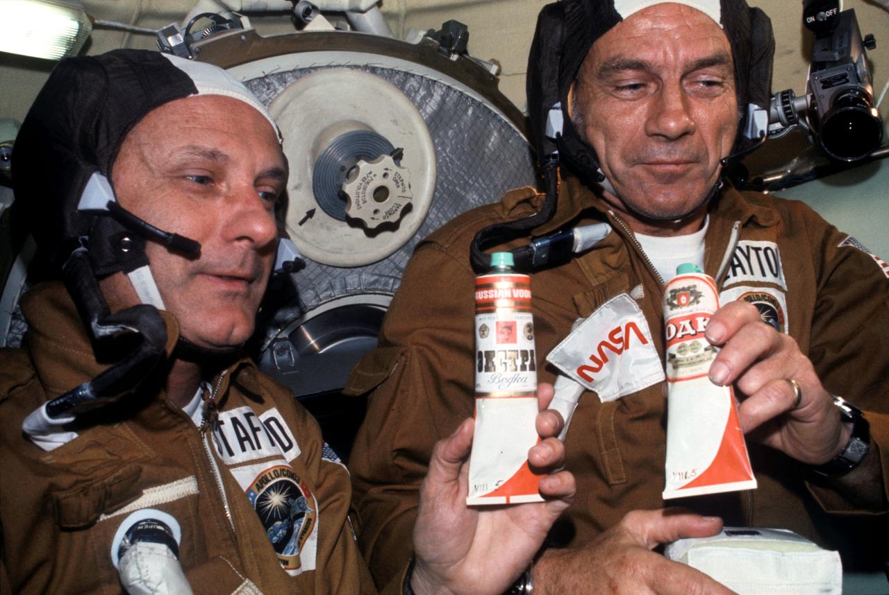 AST-03-175 (17-19 July 1975) --- Astronauts Thomas P. Stafford (left) and Donald K. Slayton hold containers of Soviet space food in the Soyuz Orbital Module during the joint U.S.-USSR Apollo-Soyuz Test Project docking mission in Earth orbit. The containers hold borsch (beet soup) over which vodka labels have been pasted. This was the crews' way of toasting each other.