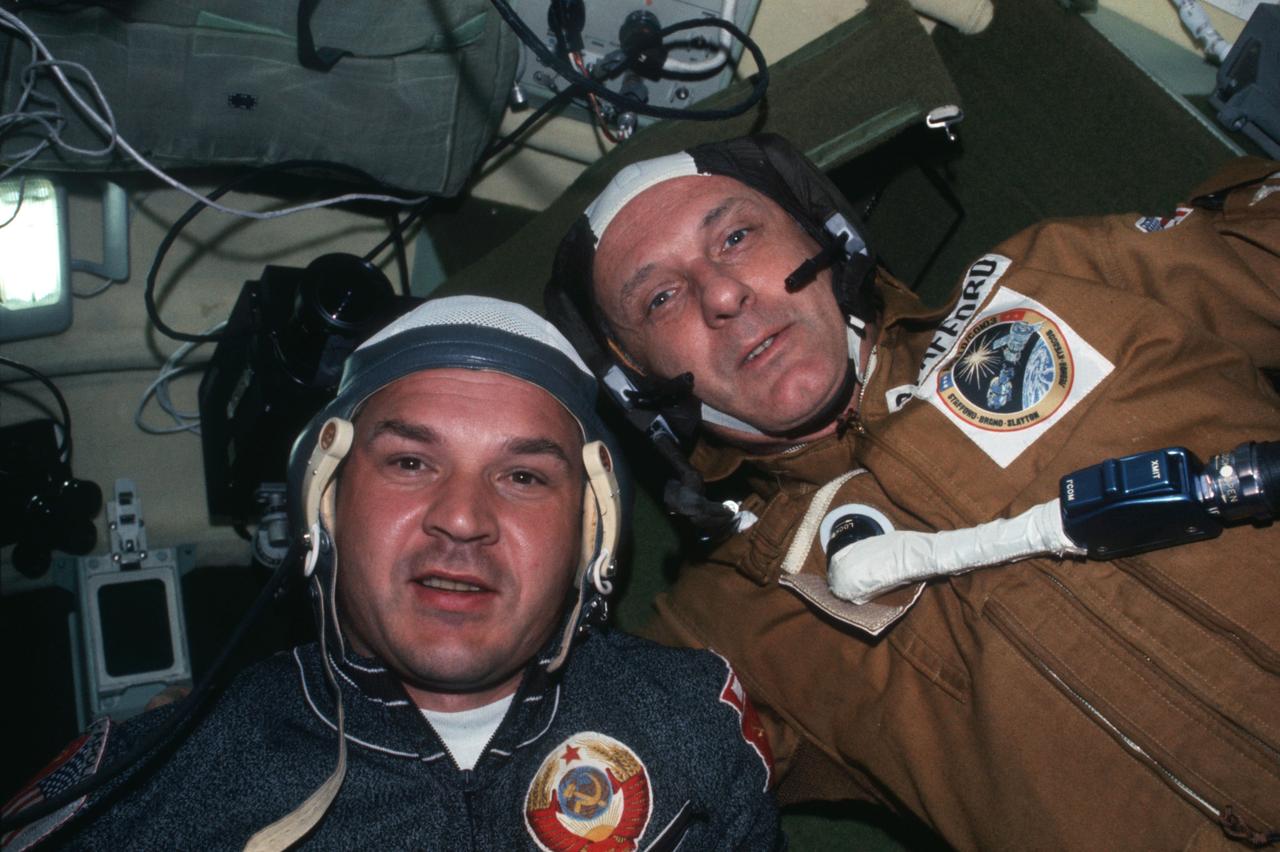AST-03-189 (17-19 July 1975) --- Cosmonaut Valeriy N. Kubasov, left, Soviet ASTP engineer; and astronaut Thomas P. Stafford, Apollo crew commander, are seen during a visit by the two crewmen to the Soviet Soyuz Orbital Module during the joint U.S.-USSR Apollo-Soyuz Test Project docking mission in Earth orbit. The visit was one of four made among the five crewmen on July 17-18-19, 1975. A 35mm camera was used to make this picture.
