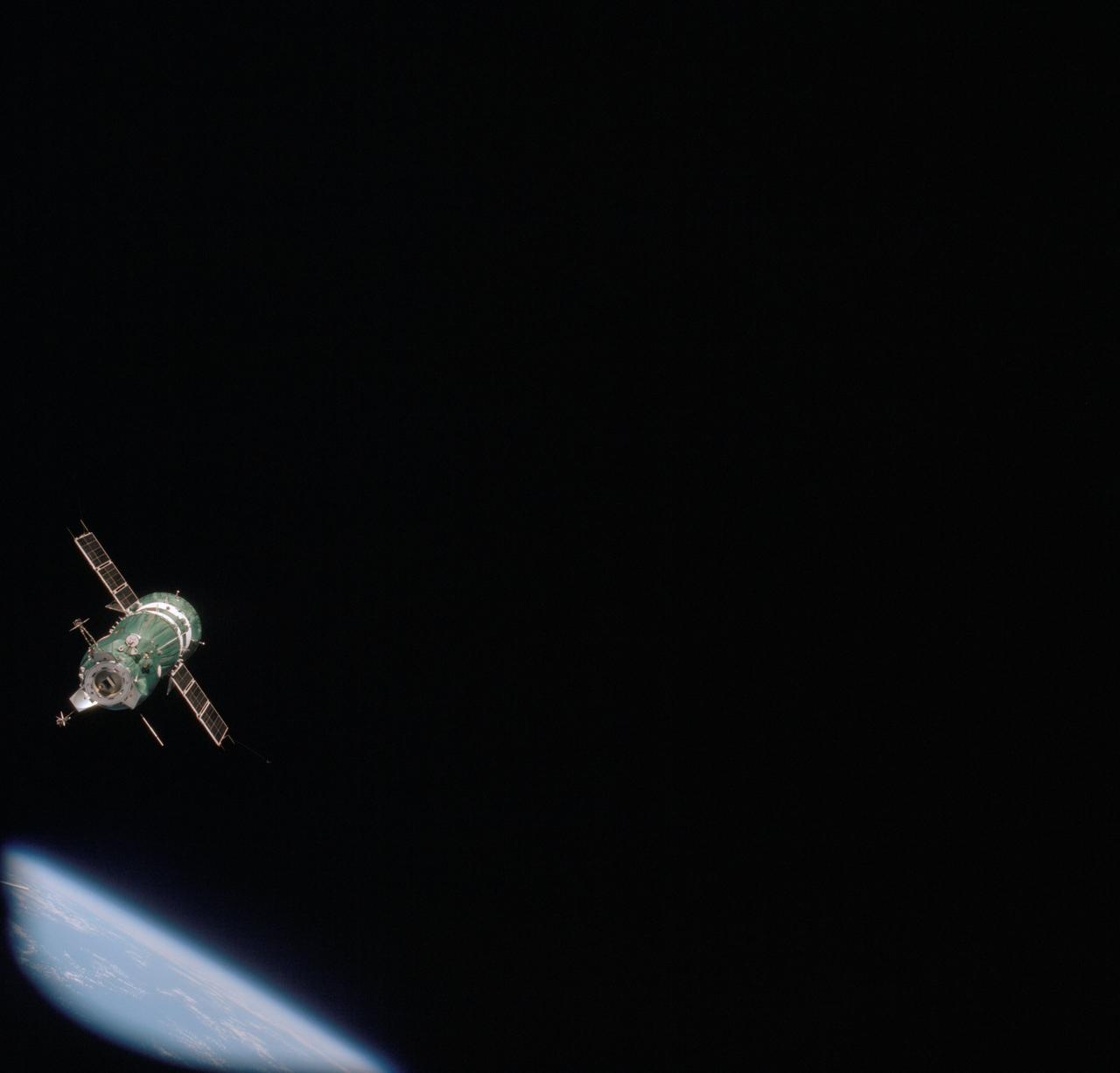 AST-09-572 (17-18 July 1975) --- The Soviet Soyuz 19 spacecraft is photographed from the American Apollo spacecraft during the joint U.S.-USSR Apollo-Soyuz Test Project (ASTP) docking mission in Earth orbit. Earth is visible in the lower left corner. This picture was taken with a 70mm camera. The Apollo crew consisted of astronauts Thomas P. Stafford, commander; Donald K. "Deke" Slayton, docking module pilot; and Vance D. Brand, command module pilot. The Soyuz 19 crew consisted of cosmonauts Aleksei A. Leonov, command pilot; and Valeri N. Kubasov, flight engineer.
