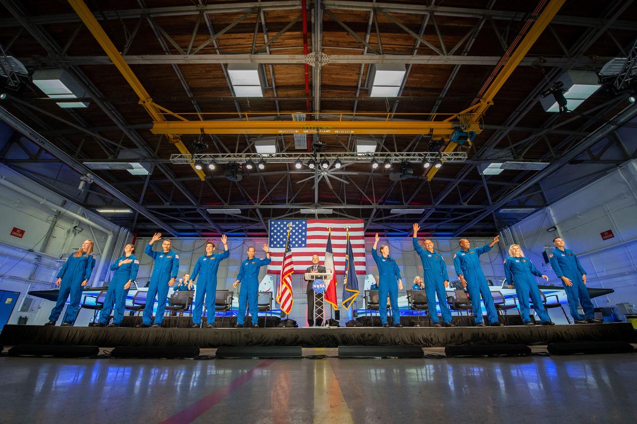 Photo Date: 2021-12-06 NASA announced its 2021 astronaut candidate class on Dec. 6, 2021. The 10 candidates, pictured here in an event at Ellington Field near NASAâ€™s Johnson Space Center in Houston are Nichole Ayers, Christopher Williams, Luke Delaney, Jessica Wittner, Anil Menon, Marcos BerrÃ­os, Jack Hathaway, Christina Birch, Deniz Burnham, and Andre Douglas.   NASAâ€™s new astronaut candidates will begin about two years of training in January 2022, after which they could be assigned to missions performing research on the International Space Station, launching from American soil on spacecraft built by commercial companies, and launching on Artemis missions to the Moon on NASAâ€™s new Orion spacecraft and Space Launch System rocket. Location: Ellington Hangar 135 Photographer: James Blair