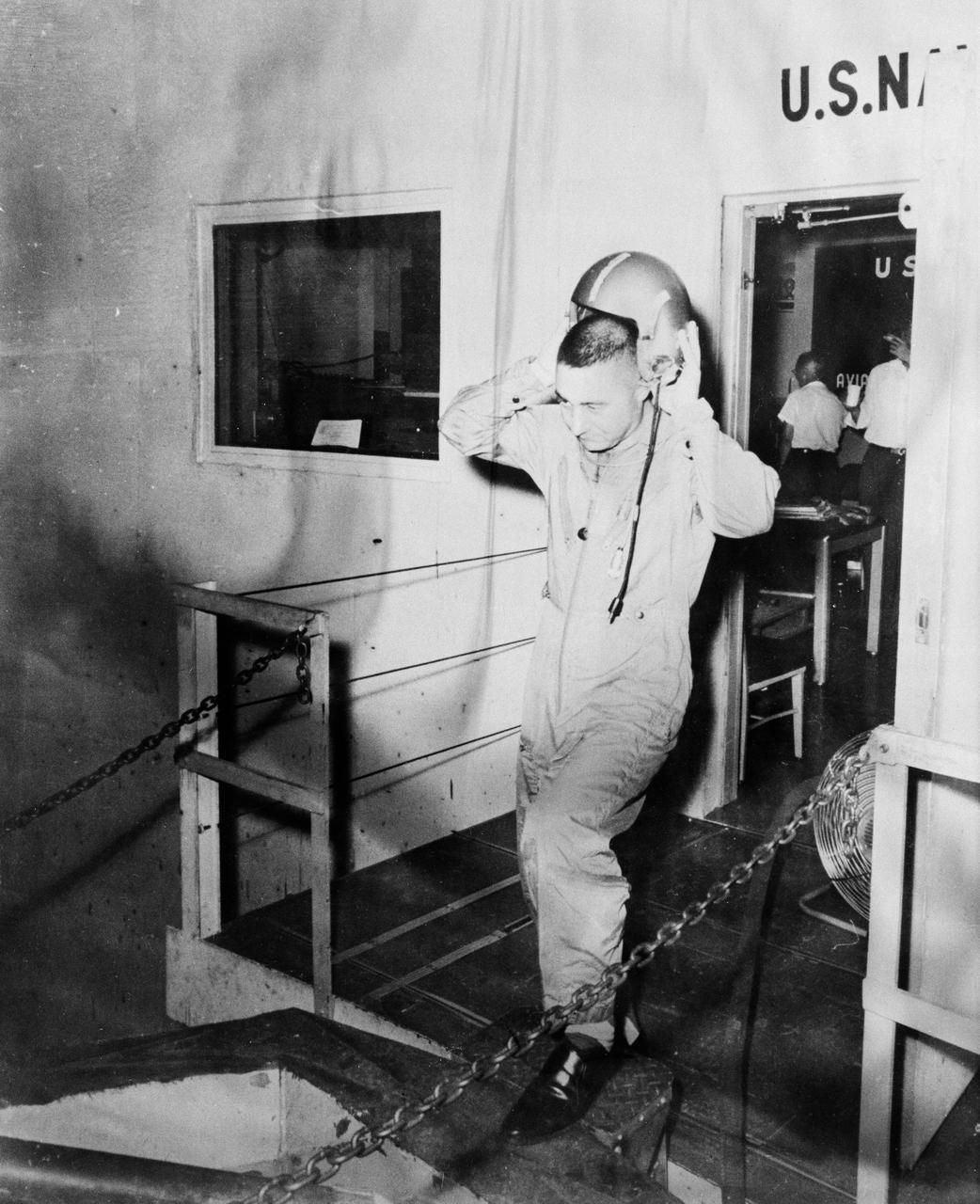 B59-00587 (1959) --- Astronaut Virgil (Gus) Grissom is pictured leaving a U.S. Navy installation and removing his helmet. Photo credit: NASA