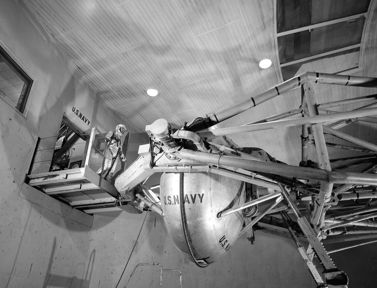 G60-02461 (1960) --- Astronaut Walter M. Schirra Jr. prepares to enter gondola of centrifuge which is used to test gravitational stress on astronauts training for spaceflight. Schirra became the pilot of the Mercury-Atlas 8 (MA-8) six-orbit space mission. Photo credit: NASA