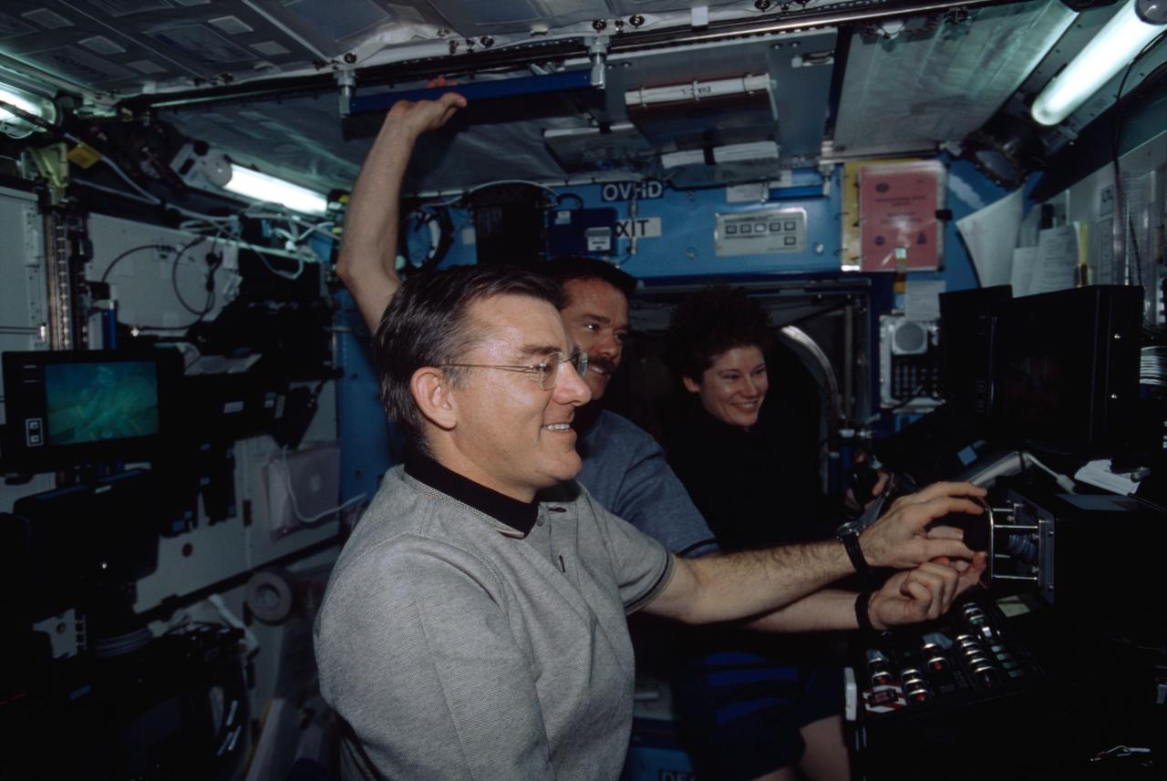 ISS002-303-036 (28 April 2001) --- Some of the principal participants of an historical event are pictured in the Destiny laboratory aboard the International Space Station (ISS). In the foreground is astronaut James S. Voss, with astronaut Chris A. Hadfield, STS-100 mission specialist, at center, and astronaut Susan J. Helms in the background. Voss and Helms are Expedition Two flight engineers. A Canadian "handshake in space" occurred at 4:02 p.m (CDT), April 28, 2001, as the Canadian-built space station robotic arm -- operated by Helms -- transferred its launch cradle over to Endeavour's robotic arm, with Canadian Space Agency astronaut Hadfield at the controls. In this scene, Hadfield had temporarily vacated his post on Endeavour's aft flight deck and was having a brief strategy meeting with the Expedition Two crew on the docked station. The exchange of the pallet from station arm to shuttle arm marked the first ever robotic-to-robotic transfer in space.