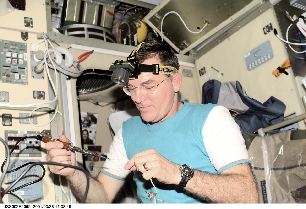 ISS002-E-5069 (28 March 2001) --- Astronaut James S. Voss, Expedition Two flight engineer, uses a soldering tool for a maintenance task in the Zvezda Service Module onboard the International Space Station (ISS).   The image was recorded with a digital still camera.