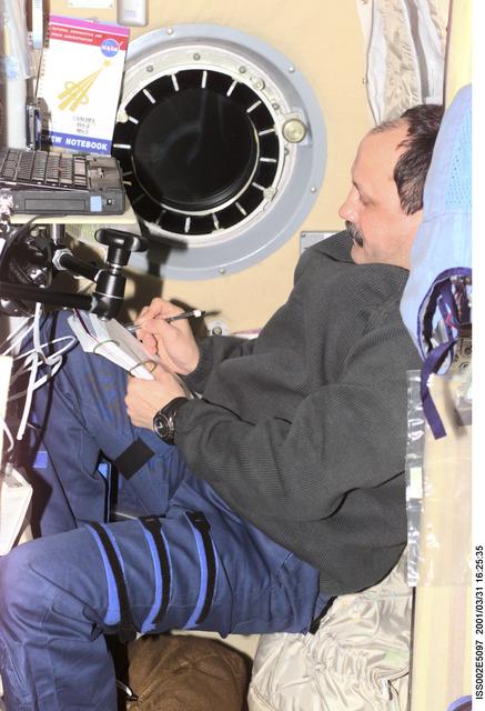 NASA image: Usachev makes notes in log in the Service Module