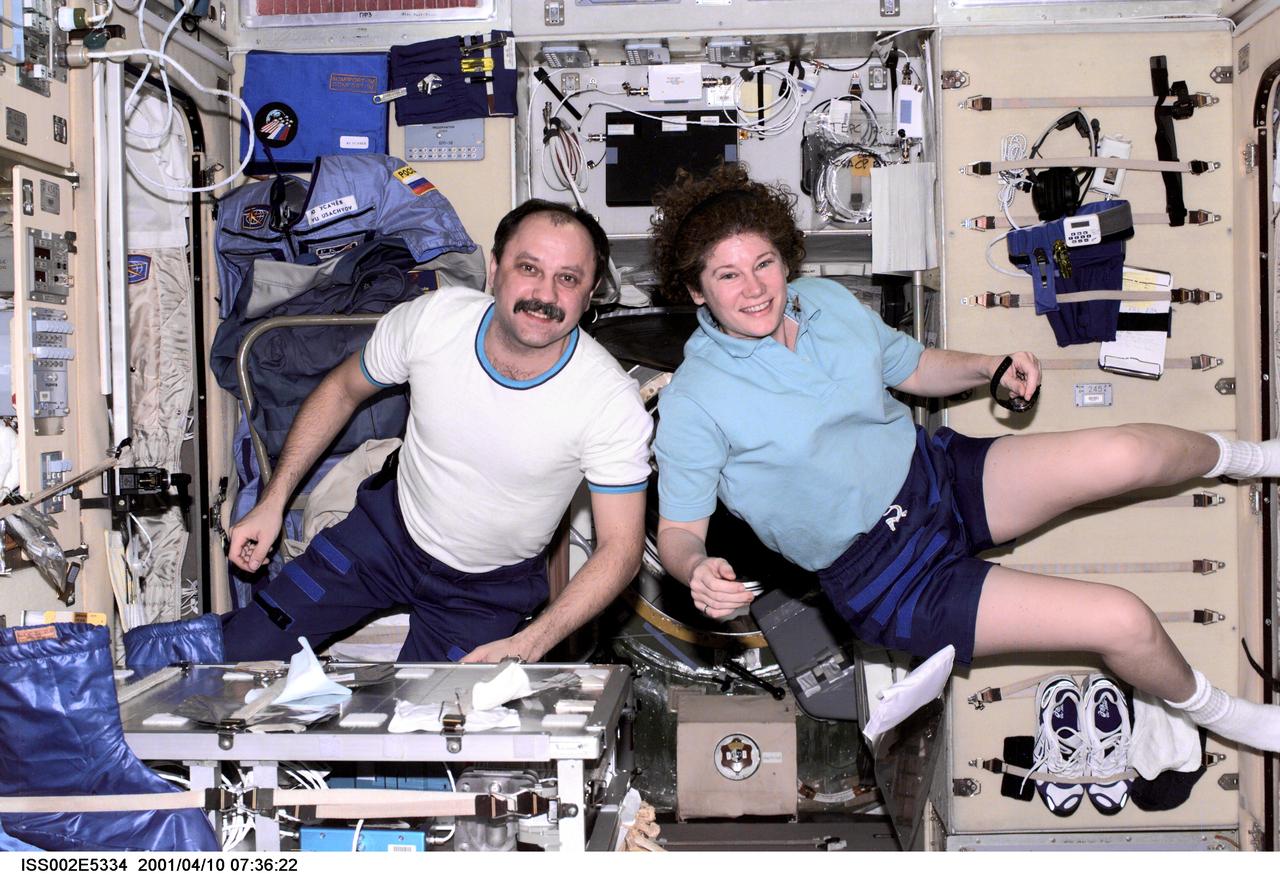 ISS002-E-5334 (10 April 2001) --- Cosmonaut Yury V. Usachev (left), Expedition Two mission commander, and astronaut Susan J. Helms, Expedition Two flight engineer, pause from their work to pose for a photograph aboard the Zvezda / Service Module of the International Space Station (ISS). This image was recorded with a digital still camera.