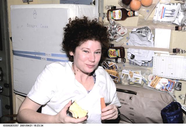 NASA image: Helms eats apple and carrot stick in Service module