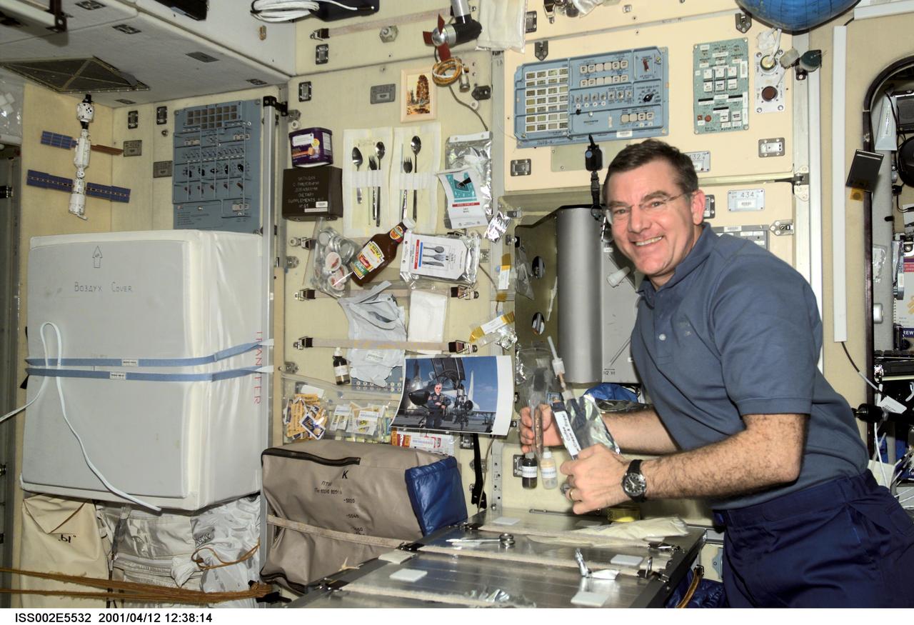 ISS002-E-5532 (12 April 2001) --- Astronaut James S. Voss, Expedition Two flight engineer, has a coffee and a snack at the table in the Zvezda / Service Module of the International Space Station (ISS).   This image was recorded with a digital still camera.