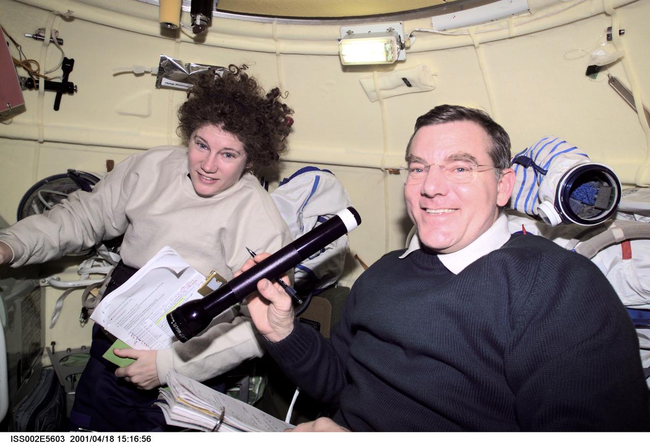 ISS002-E-5603 (18 April 2001) --- Astronauts Susan J. Helms and James S. Voss, both Expedition Two flight engineers, share a task in the Soyuz spacecraft which is docked to the International Space Station (ISS). The image was recorded with a digital still camera.