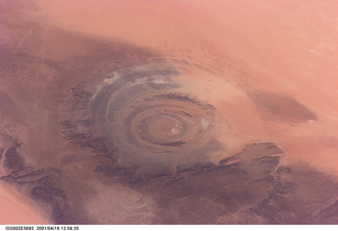 ISS002-E-5693 (19 April 2001) --- The &quot;bull's-eye&quot; of the Richat Structure adds interest to the barren Gres de Chinguetti Plateau in central Mauritania in northwest Africa. It represents domally uplifted, layered (sedimentary) rocks that have been eroded by water and wind into the present shape. The 25-mile-wide structure is a 300-foot-deep landmark that has caught the eye of many an astronaut in Earth orbit. Image number ISS002-E-5457 shows the same feature six days earlier.  The image was recorded with a digital still camera.