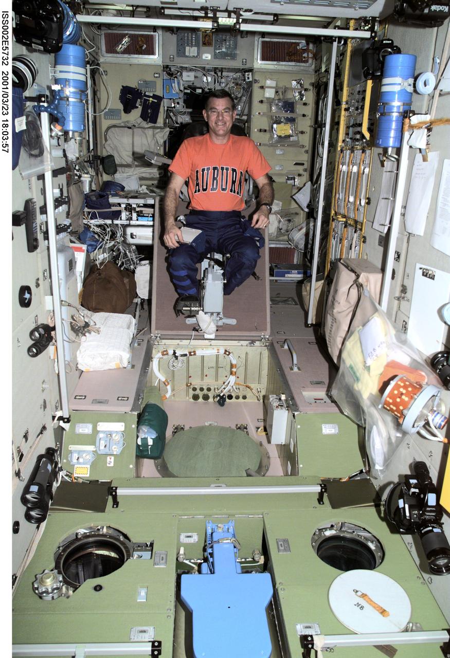 ISS002-E-5732 (23 March 2001) --- James S. Voss, Expedition Two flight engineer, prepares to exercise on the cycle ergometer in the Zvezda Service Module.  The image was taken with a digital still camera.
