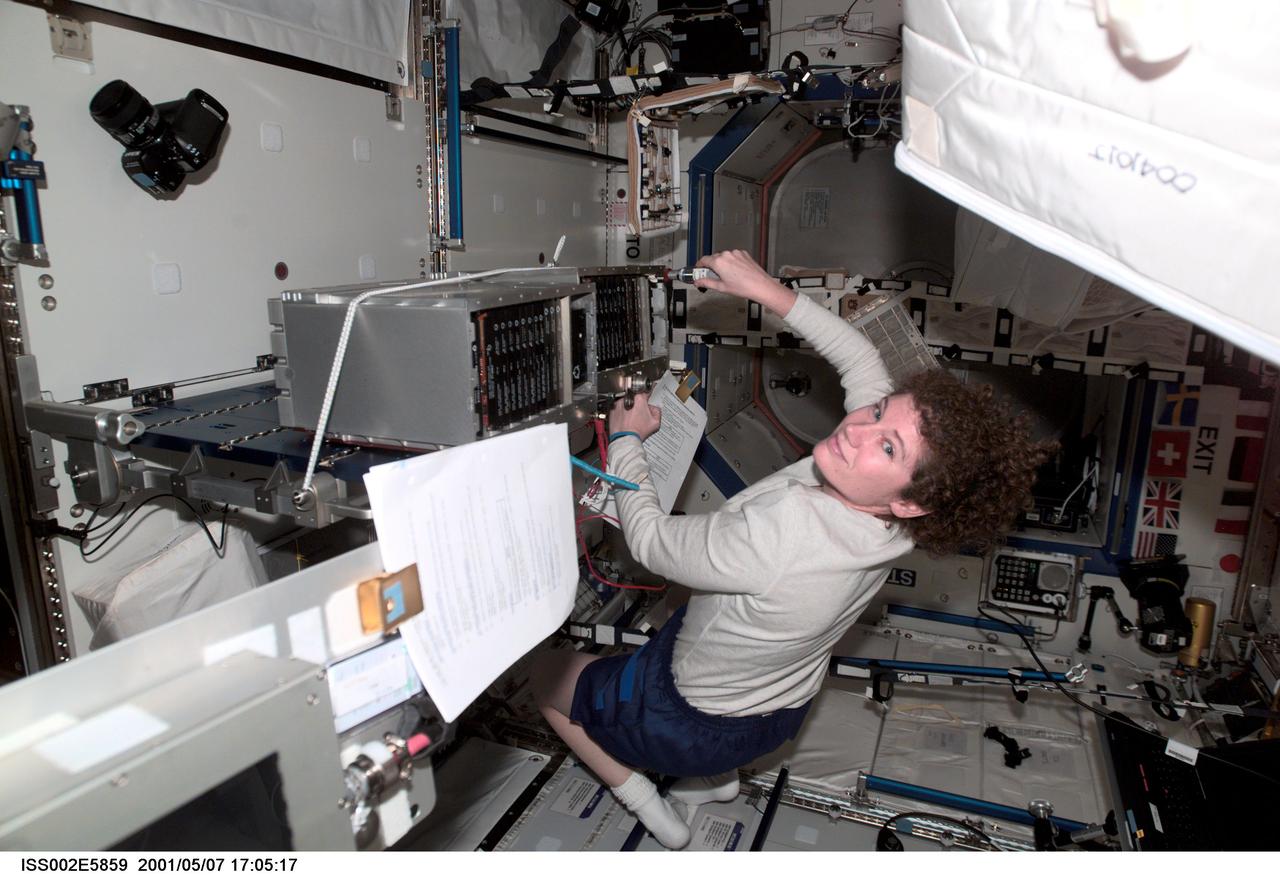 ISS002-E-5859 (7 May 2001) --- Susan J. Helms, Expedition Two flight engineer, works on an Enhanced Space Station Multiplexer / Demultiplexer (ESSMDM) at the Maintenance Work Assembly (MWA) work surface in the Destiny module. The image was taken with a digital still camera.