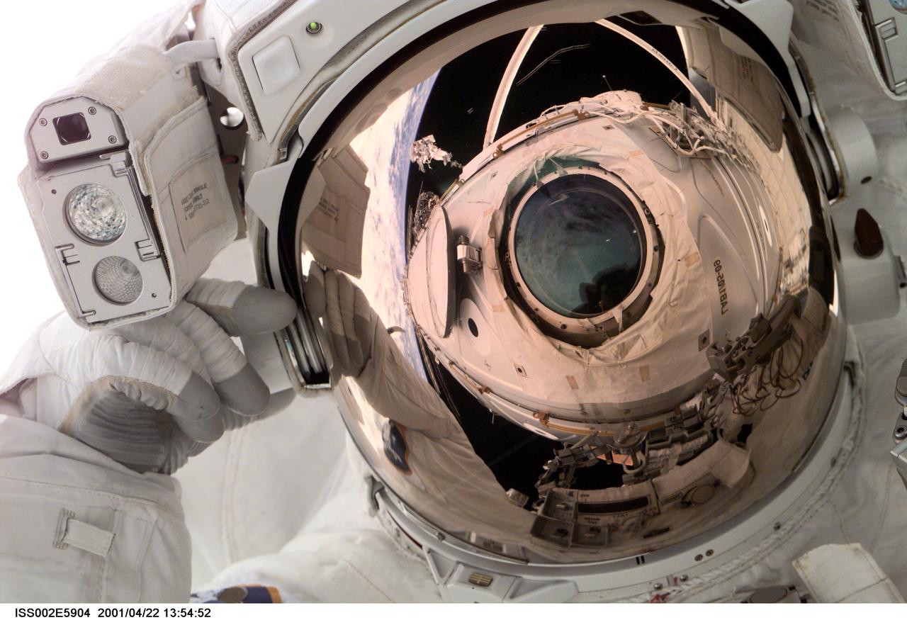 ISS002-E-05904 (24 April 2001) --- Astronaut Scott E. Parazynski, mission specialist, was photographed with a digital still camera by one of the Expedition Two crewmembers aboard the International Space Station (ISS) during the first of two scheduled STS-100 spacewalks. The window on Destiny through which the photo was made is reflected in Parazynski's gold helmet visor. Astronauts Parazynski and Chris A. Hadfield were working to install the Space Station Remote Manipulator System (SSRMS) or Canadarm2 during this extravehicular activity (EVA). Hadfield, representing the Canadian Space Agency (CSA), is reflected in the visor as well.