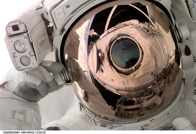 NASA image: Reflection of Destiny lab window in astronaut faceplate