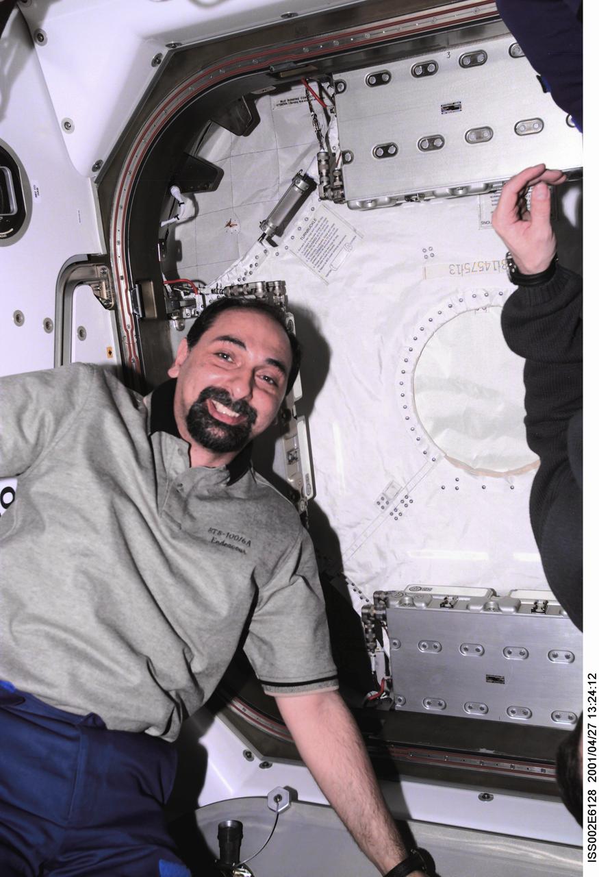 ISS002-E-6128 (27 April 2001) --- Umberto Guidoni of the European Space Agency (ESA), STS-100 mission specialist, poses for a photograph in Unity Node 1 as the hatch to the Multipurpose Logistics Module (MPLM) Raphaello is being closed near the end of the STS-100 mission. The image was taken with a digital still camera.