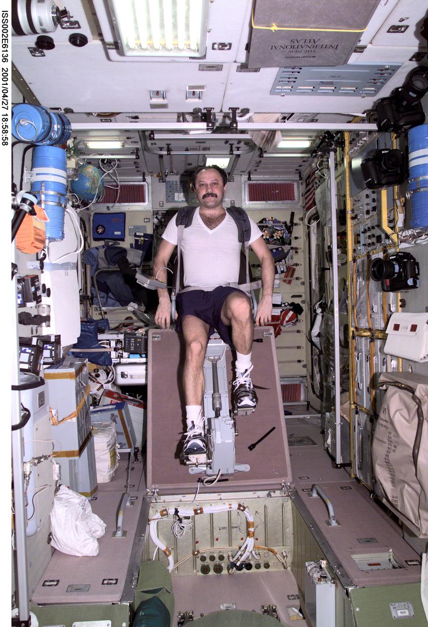 ISS002-E-6136 (27 April 2001) --- Yury V. Usachev of Rosaviakosmos, Expedition Two mission commander, exercises on the cycle ergometer in the Zvezda Service Module.  The image was taken with a digital still camera.