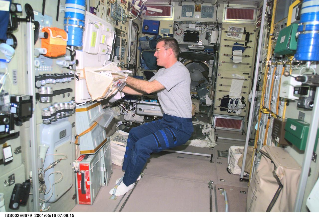ISS002-E-6679 (16 May 2001) --- James S. Voss, Expedition Two flight engineer, goes through a stowage bag in the Zvezda Service Module.  This image was taken with a digital still camera.