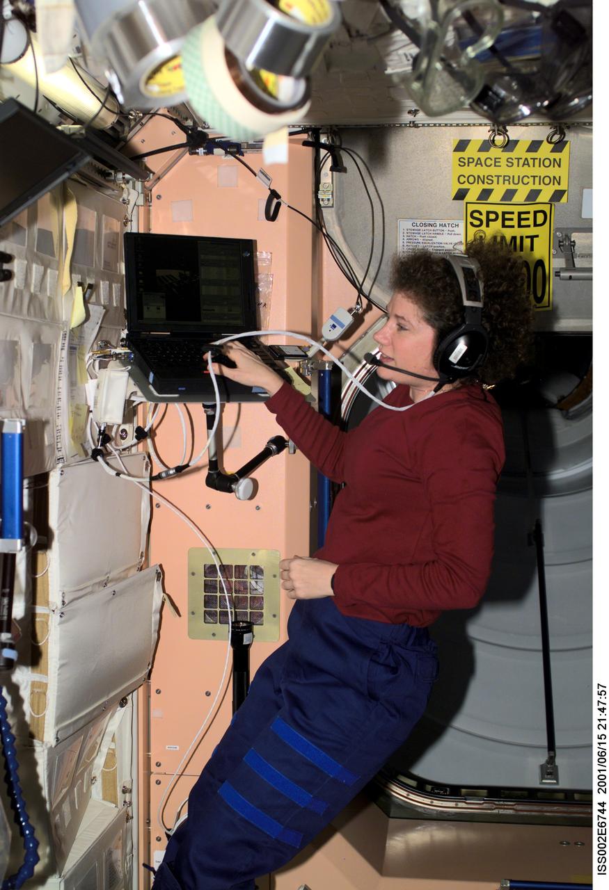 ISS002-E-6744 (15 June 2001) --- Susan J. Helms, Expedition Two flight engineer, talks with mission control while working on a laptop computer in Unity Node 1.