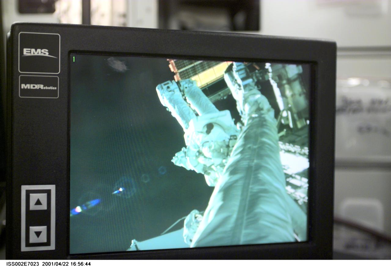 ISS002-E-7023 (22 April 2001) - Viewed on a monitor in the Destiny/U.S. Laboratory, Astronaut Chris A. Hadfield, STS-100 mission specialist representing the Canadian Space Agency (CSA), can be seen during the first space walk (EVA-1) of the STS-100 mission.  The image on the monitor was taken with the Canadian-built Remote Manipulator System (RMS) arm  video camera, and this still image was recorded with a digital still camera.