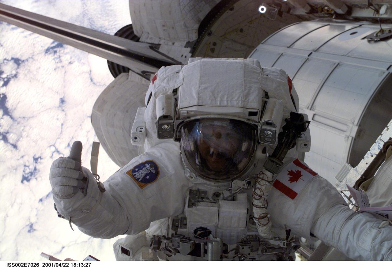 ISS002-E-7026 (22 April 2001) --- Astronaut Chris A. Hadfield, mission specialist representing the Canadian Space Agency (CSA), gives fellow astronauts the thumbs up during the first space walk (EVA-1) of the STS-100 mission.  This digital picture was taken through the nadir window of the  Destiny/U.S. Laboratory.