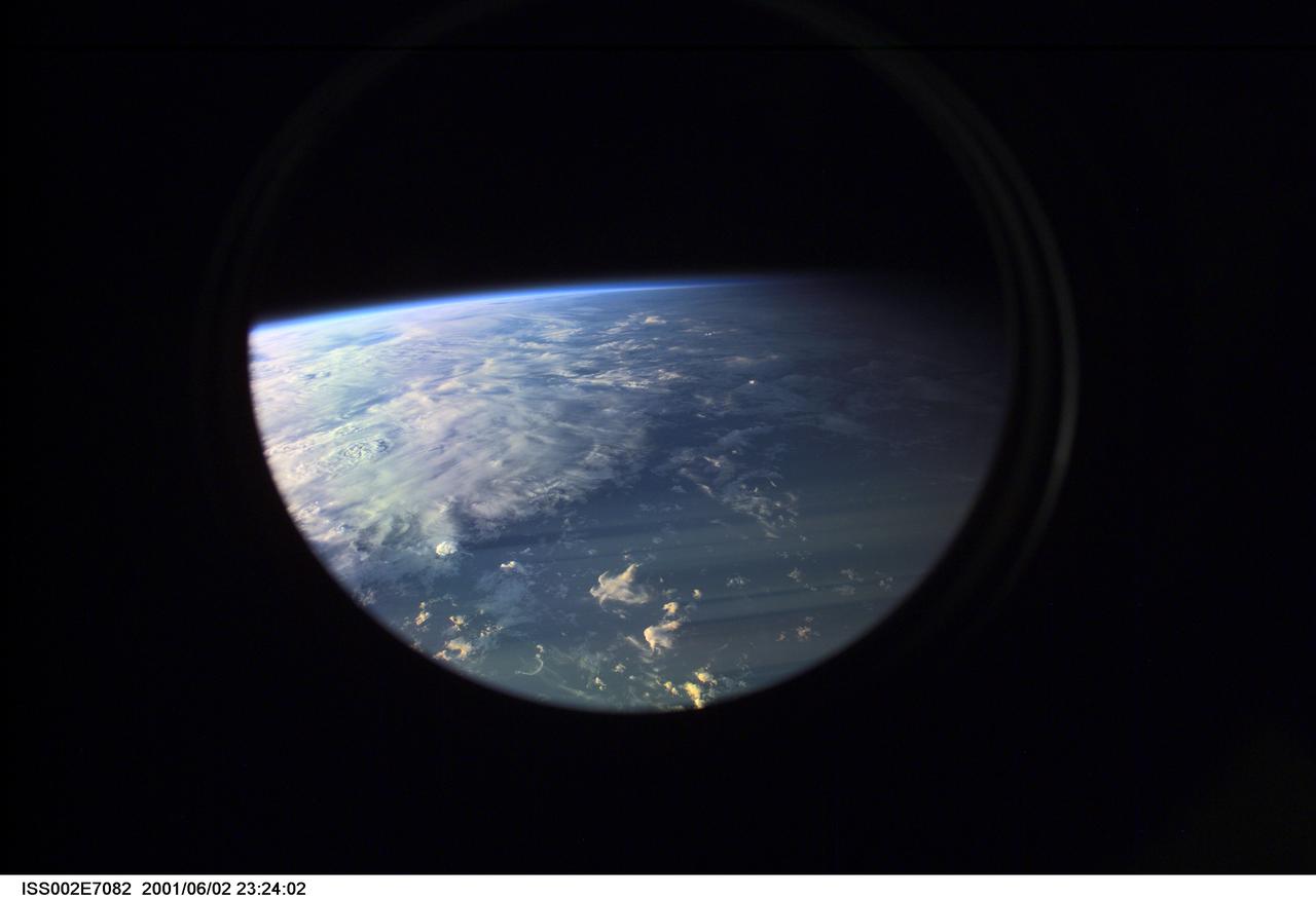 ISS002-E-7082 (2 June 2001) --- Earth's limb at sunset as photographed by one of the Expedition Two crew members with a digital still camera aimed through the nadir window of the U.S. laboratory Destiny.  Beneath the limb, a large mass of clouds fills the window.