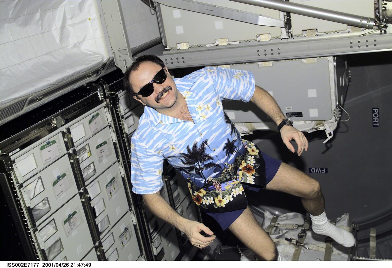 ISS002-E-7177 (26 April 2001) --- Rosaviakosmos cosmonaut Yury V. Usachev, Expedition Two commander, currently hosting six astronauts and a cosmonaut from the Endeavour's STS-100 mission, joins in the dress mode of the day--Hawaiian shirt and sunshades--as he pitches in to help in the moving process.  He is in the recently-docked Italian-built Raffaello Multi-Purpose Logistics Module, which will return to Earth with the shuttle. The photo was recorded with a digital still camera.