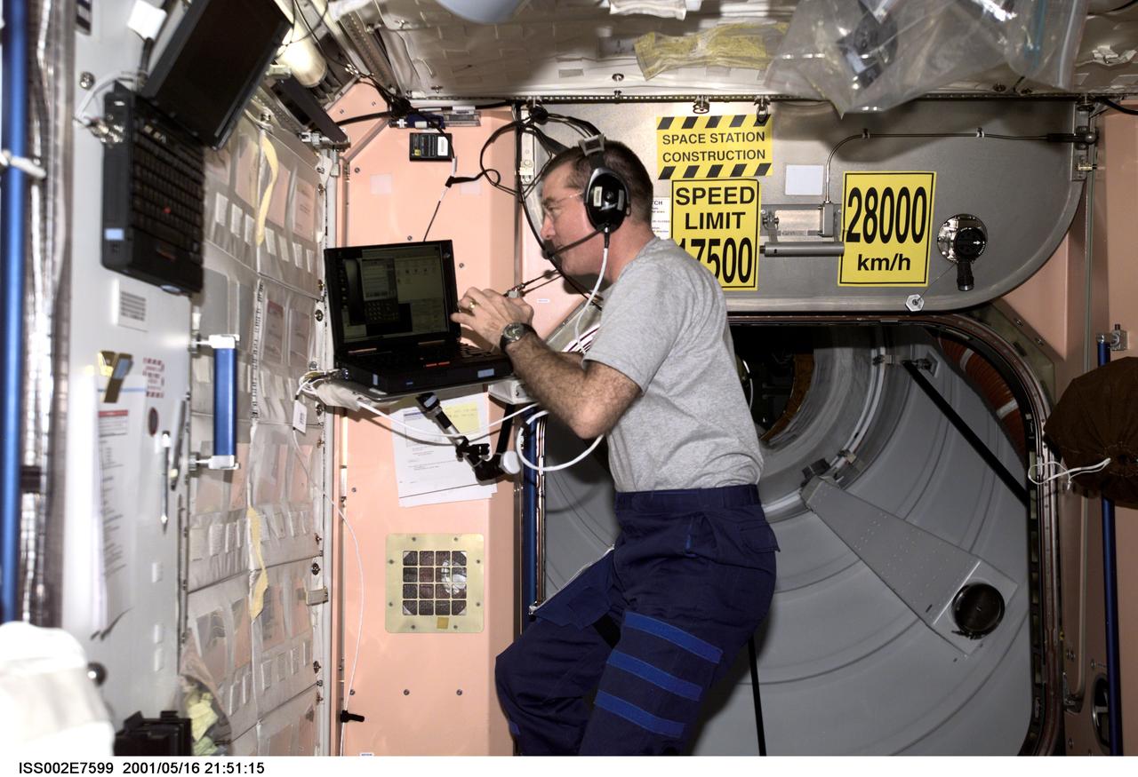 ISS002-E-7599 (16 May 2001) --- James S. Voss, Expedition Two flight engineer, communicates with Mission Control as he works on a laptop computer in Unity Node 1.  The image was taken with a digital still camera.